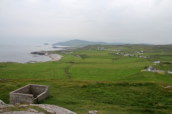 a wide view of green pastures and the sea