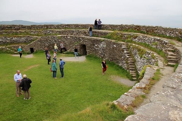 A group of people walking around a large stone fort