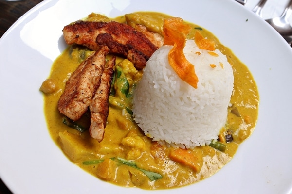 vegetable curry topped with chicken tenders and a scoop of white rice