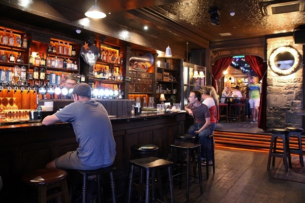 A group of people sitting inside an Irish pub