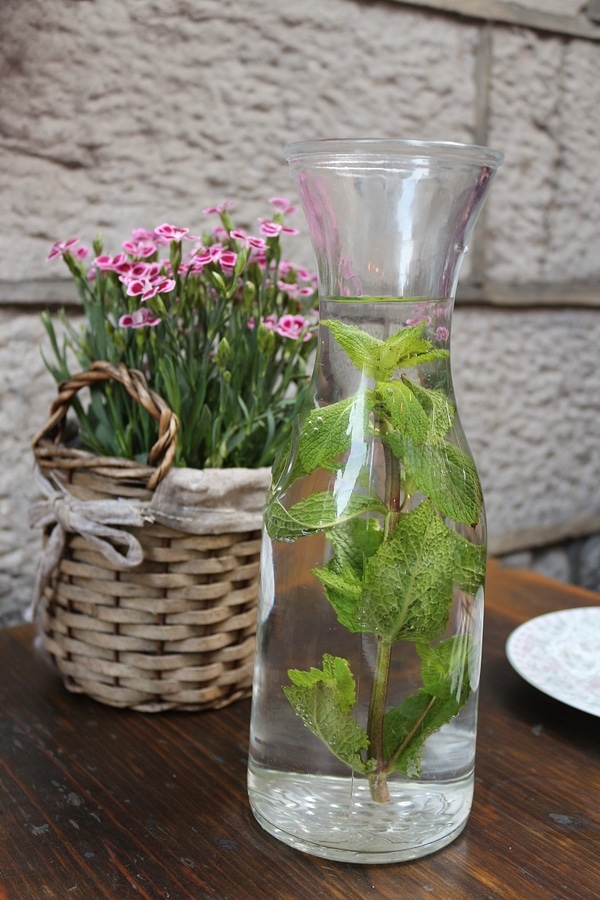 A basket of flowers and a bottle of water on a table