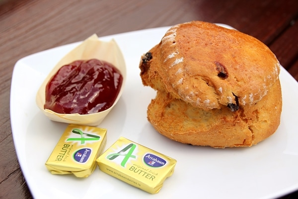 a scone with a side of butter and jam