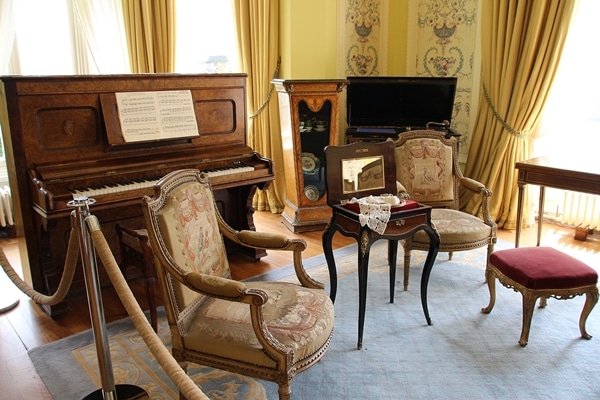 A living room filled with ornate chairs and a piano