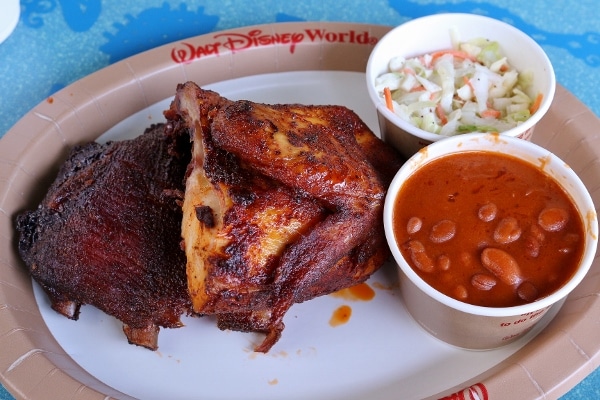 a plate of barbecue chicken with cole slaw and baked beans