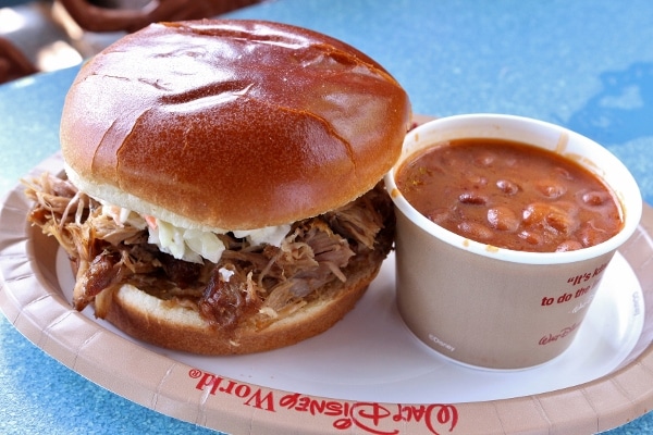 a pulled pork sandwich with a side of baked beans