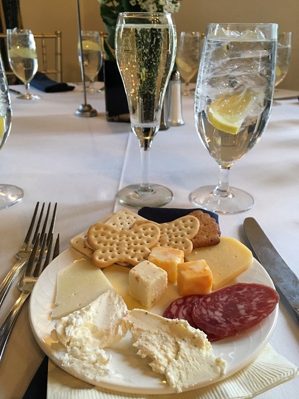 a cheese plate and a glass of sparkling wine