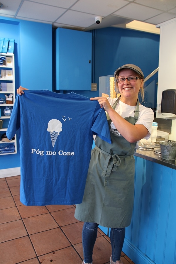 a woman holding up a tee shirt