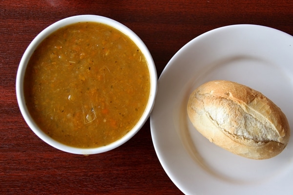 A bowl of soup and a bread roll