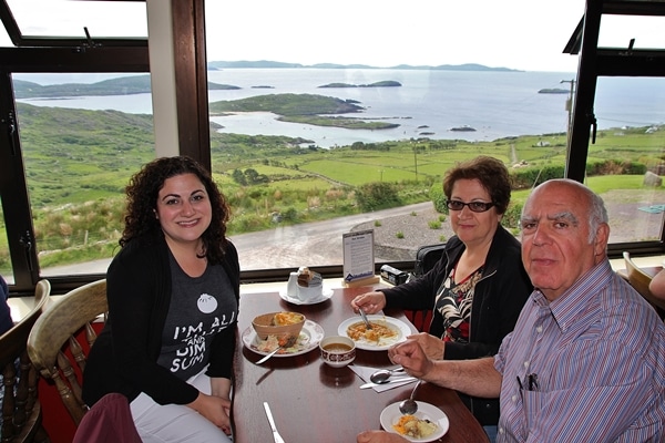 A group of people sitting at a restaurant table by a large window