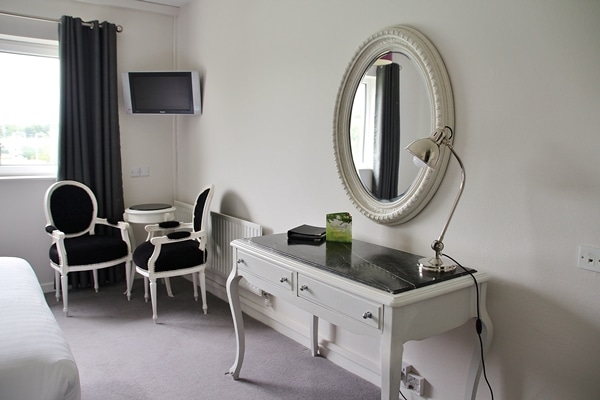 a desk and mirror in a hotel room