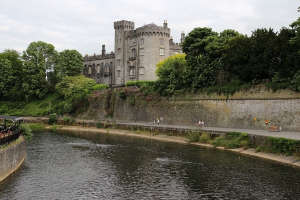 view of Kilkenny Castle from a bridge over a river