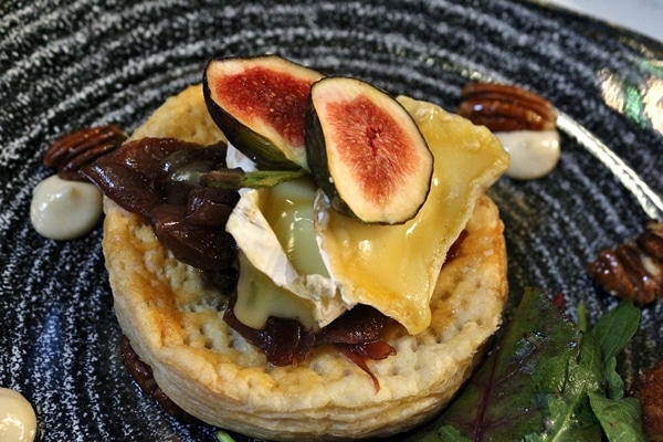 closeup of a tart topped with cheese and figs