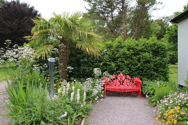 a red bench in a garden