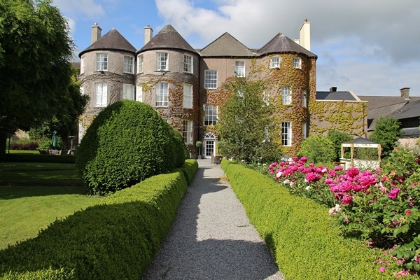 A large stone building with a garden in front