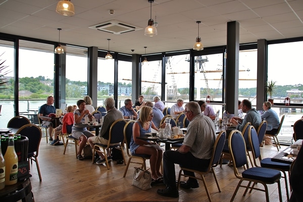 A group of people sitting in a restaurant with large windows