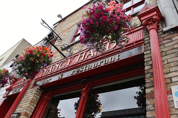 A sign above a restaurant that says Nancy Hands