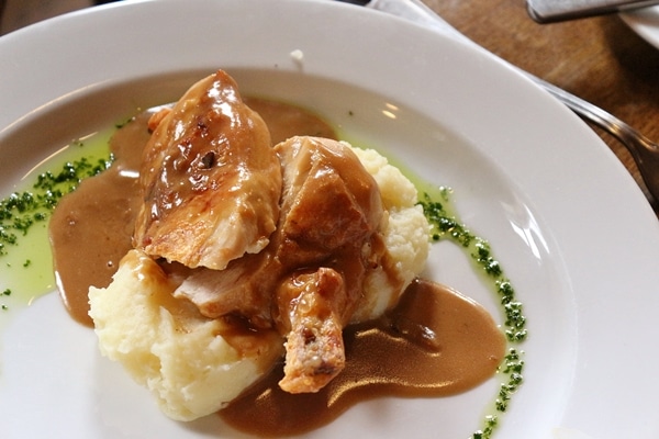 A plate of meat with mashed potatoes and gravy