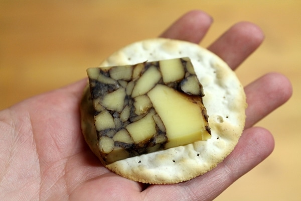 a piece of wine infused cheese on a cracker