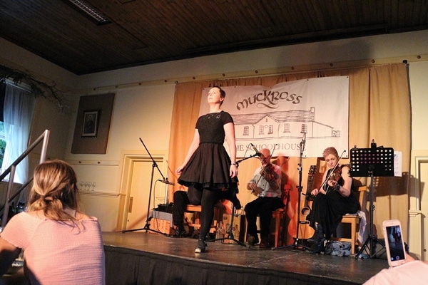 a woman dancing on a stage in front of a band