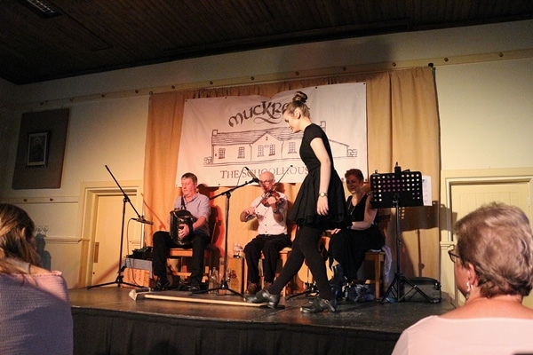 a woman with a broom dancing on stage