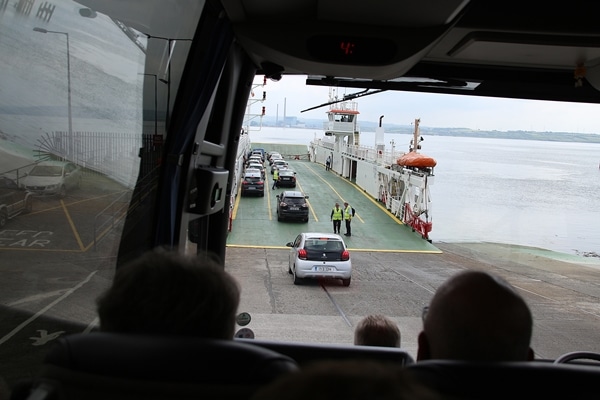 view of cars driving onto a ferry