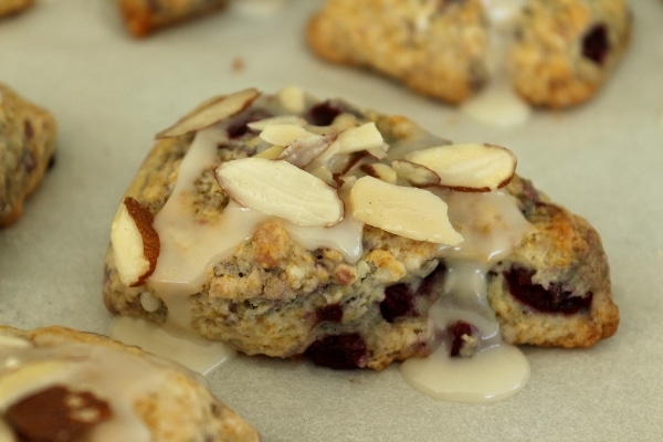 side view of a scone topped with glaze and sliced almonds