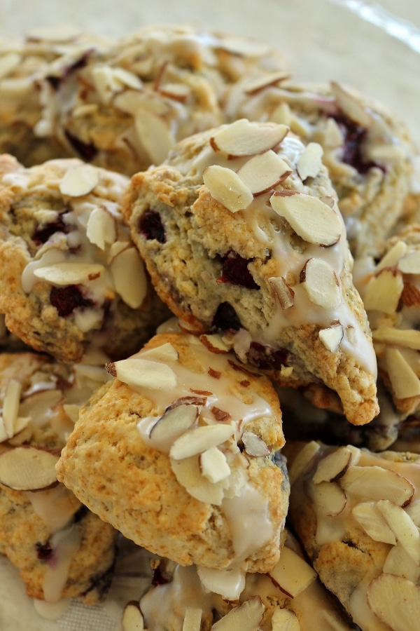 a platter of scones topped with glaze and sliced almond