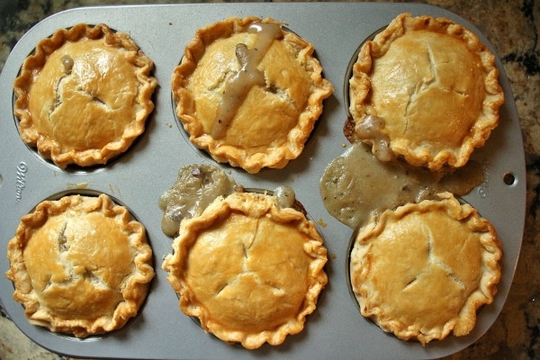 6 small pies assembled in a jumbo muffin pan, baked and golden with juices bubbling out