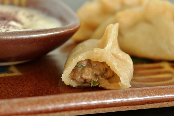 A close up of a half eaten dumpling filled with meat
