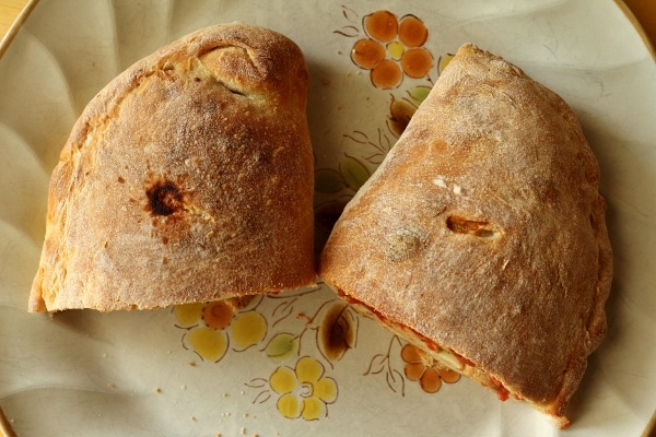 A calzone cut in half on a plate