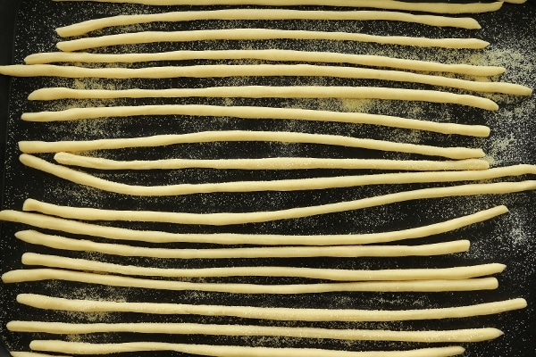Hand-rolled uncooked pasta on a black tray