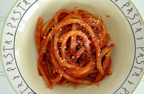 Hand-rolled pici pasta in tomato sauce, topped with grated cheese