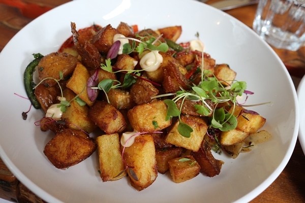 fried cubed potatoes on a white plate