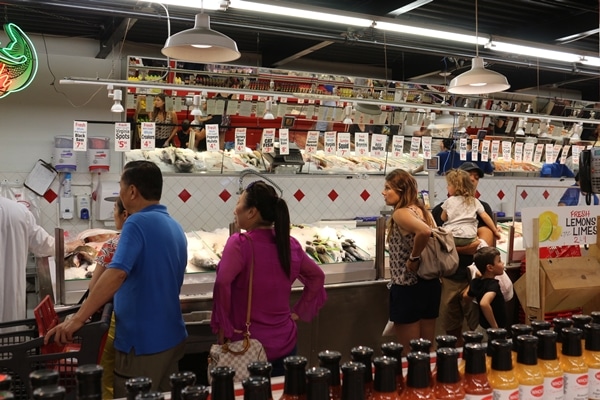 A group of people standing in supermarket