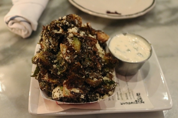 a plate of fried brussels sprouts with dipping sauce