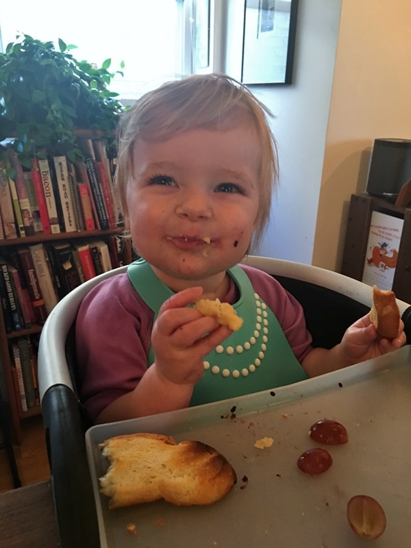 A little girl sitting at a table eating food