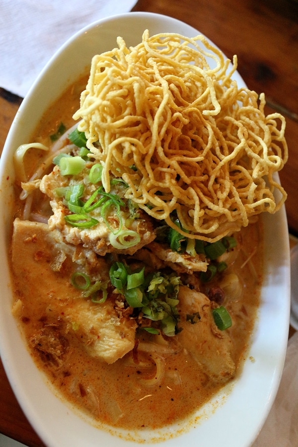 a brothy bowl of noodles with chicken