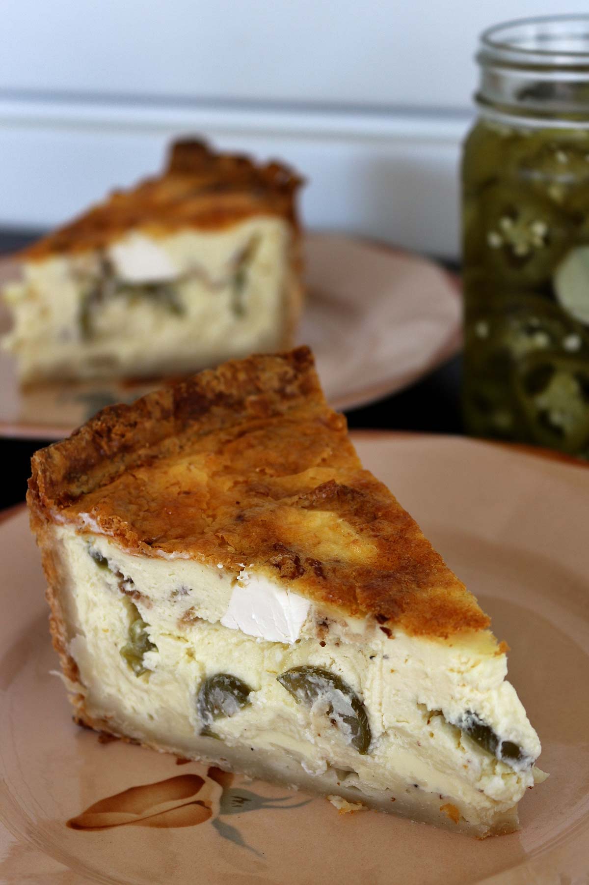 Closeup of a slice of jalapeño popper quiche on an antique plate with flowers on it.