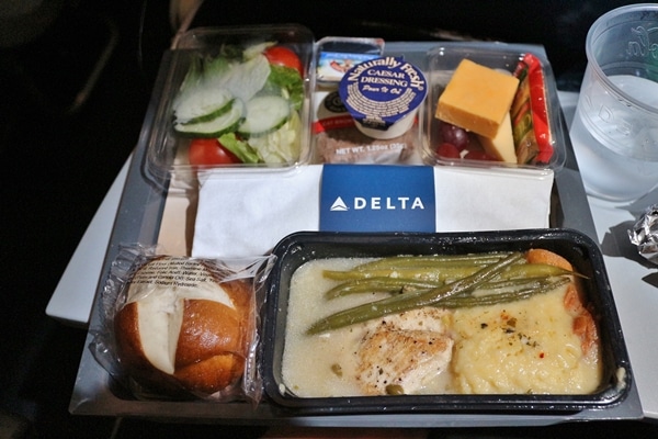 an airplane meal of chicken  with salad