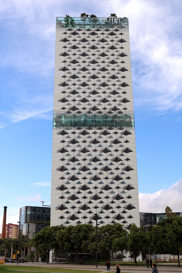 a tall building with windows shaped like palms