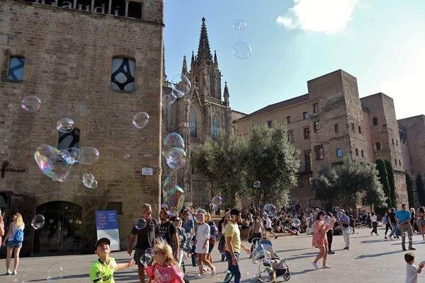 A group of people walking in front of a church with bubbles in the air