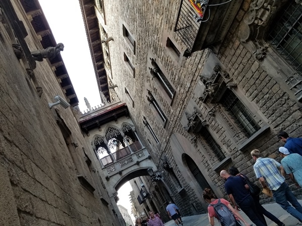 an arched bridge between 2 stone buildings