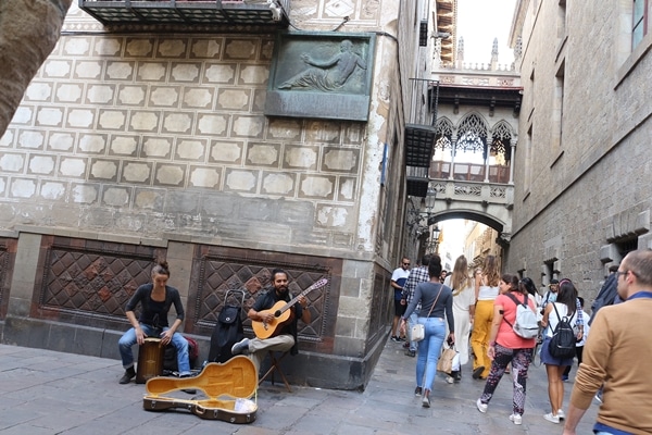 A group of people walking performing music in Barcelona\'s Gothic Quarter