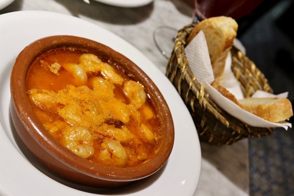 A bowl of garlic shrimp with bread