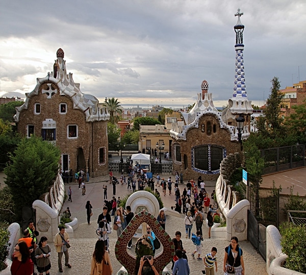 A group of people standing in front of a couple peculiar looking buildings