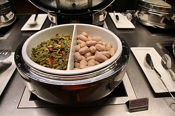 vegetables and sausages on a buffet line