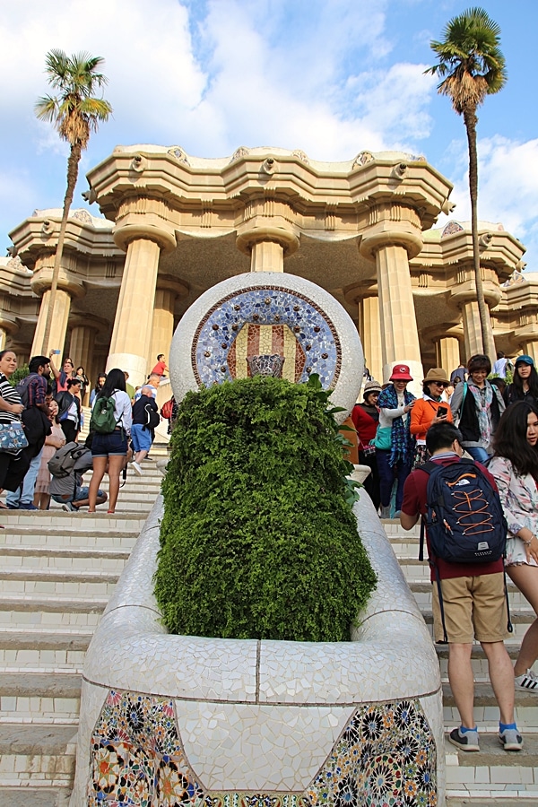 A group of people standing on either side of a mosaic sculpture