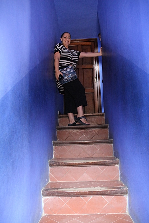 A person standing in a blue stairwell