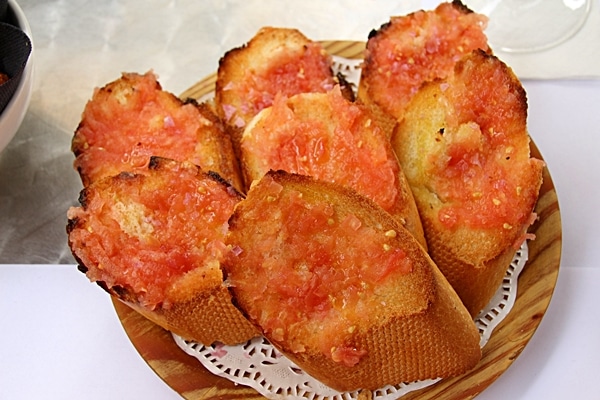 a plate of toasted bread topped with tomato puree