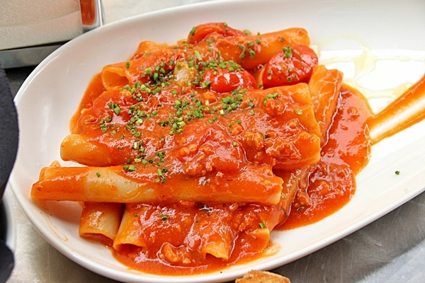 large pasta noodles in tomato sauce on a white plate